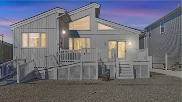 A two-story house with a front porch, a staircase, and a fenced yard. - Fully renovated modern beach home in Orltey Beach
 (Seaside Heights)