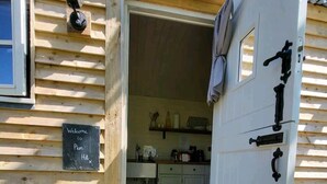 Una cabaña de madera con un letrero que dice 'Welcome to Plum Hut'.