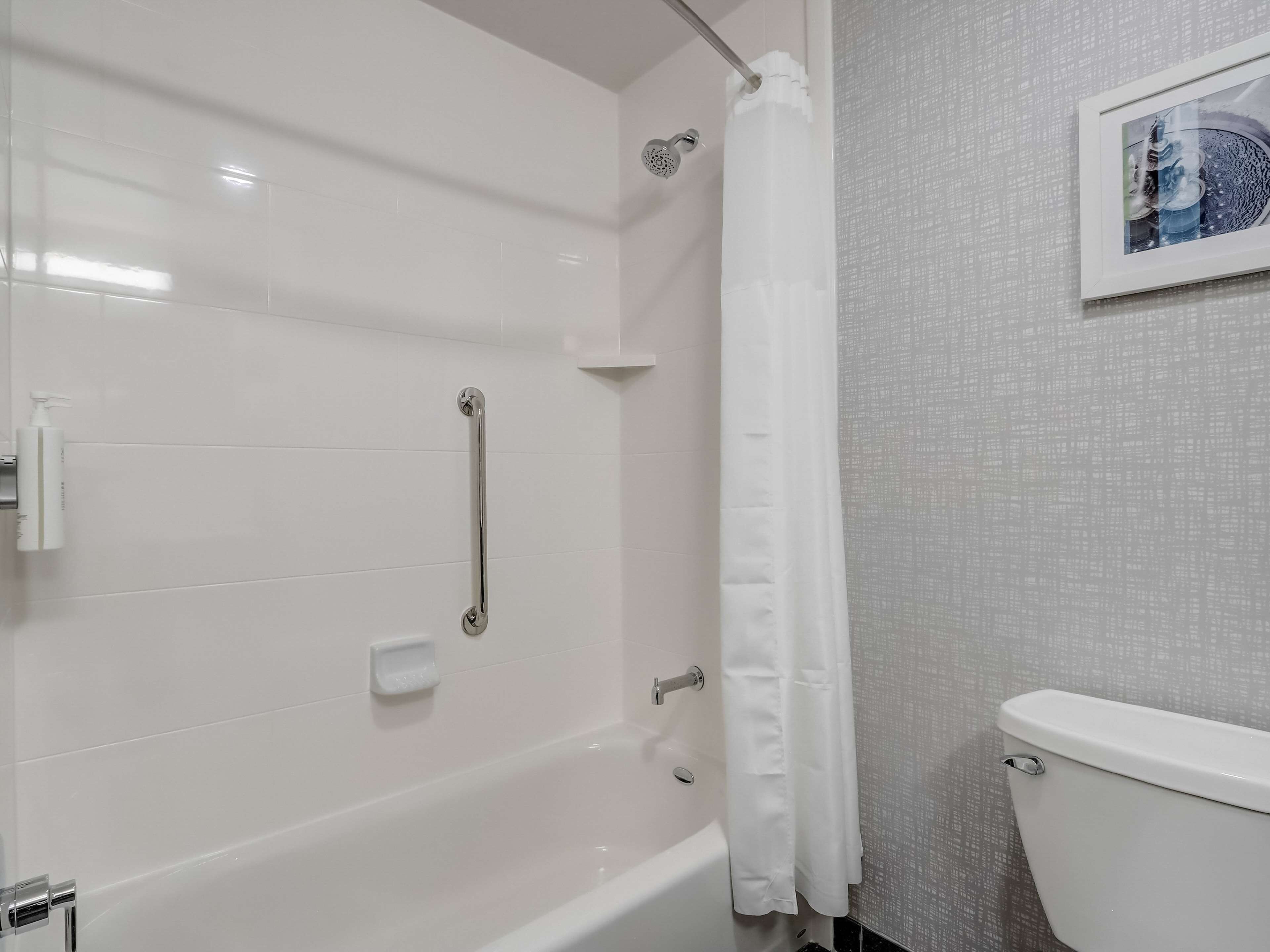 Un baño moderno con bañera, ducha e inodoro.