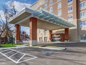 A modern building with a covered entrance, a parking lot with a handicapped parking space, and a sign indicating reserved parking. - Hampton Inn & Suites Cincinnati Midtown Rookwood (Cincinnati)