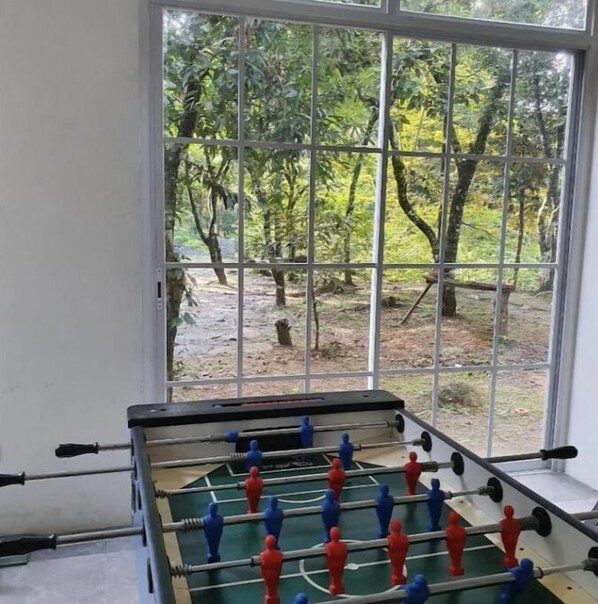 Enjoy a peaceful view of the surrounding woods from the large window, where a foosball table awaits your game.