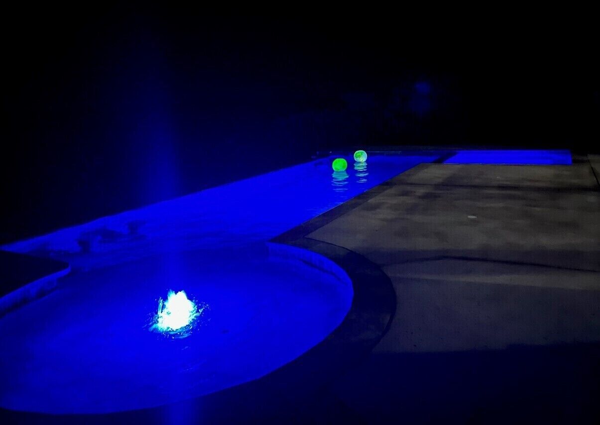 A pool area with a blue-lit water feature and a concrete deck.