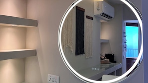 A modern bathroom with a round mirror, built-in shelves, and an air conditioning unit. - Matteo Villa Limassol Cyprus (Limassol)
