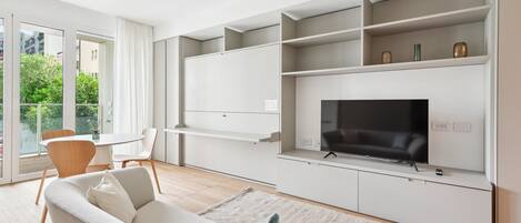 A modern living room with a sofa, TV, and built-in shelves.