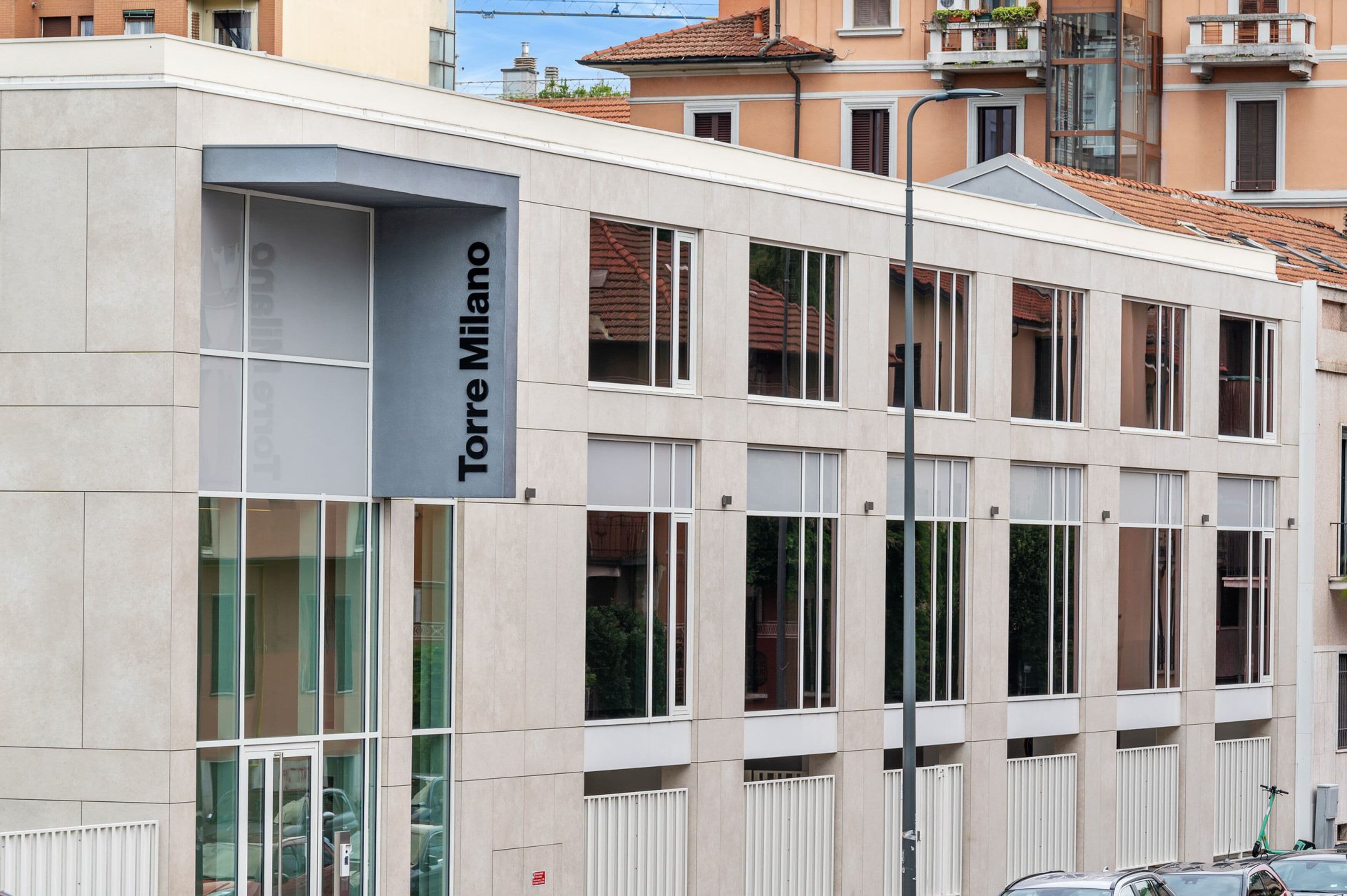 Un edificio moderno con un cartel que dice "Torre Milano".
