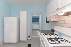 Compact kitchen with refrigerator, stove, and storage for everyday essentials.