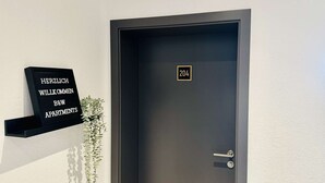 A dark door with a number plate '204' and a sign above it reading 'HERZLICH WILKOMMEN B&W APARTMENTS'. - B&W Apartments - 1. Etage Wohnung (Morschen)
