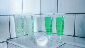 Fire flasker mineralspa shampoo og bade- og brusegel på en fliset overflade.