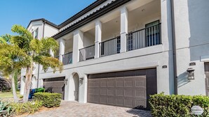 Ein zweigeschossiges Wohngebäude mit überdachter Veranda, Garage und gepflegtem Garten.