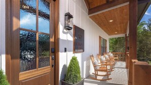 A wooden porch with rocking chairs and a sign reading "Chapel Lounge".