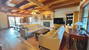 A spacious living room with a fireplace, a large sofa set, and a dining area. - Gorgeous Views and only 13 mi to Lost Maples SNA, 22 mi to Garner State Park! (Utopia)