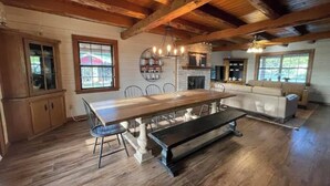 A spacious kitchen with a large wooden table, built-in cabinets, and a stone fireplace. - Gorgeous Views and only 13 mi to Lost Maples SNA, 22 mi to Garner State Park! (Utopia)