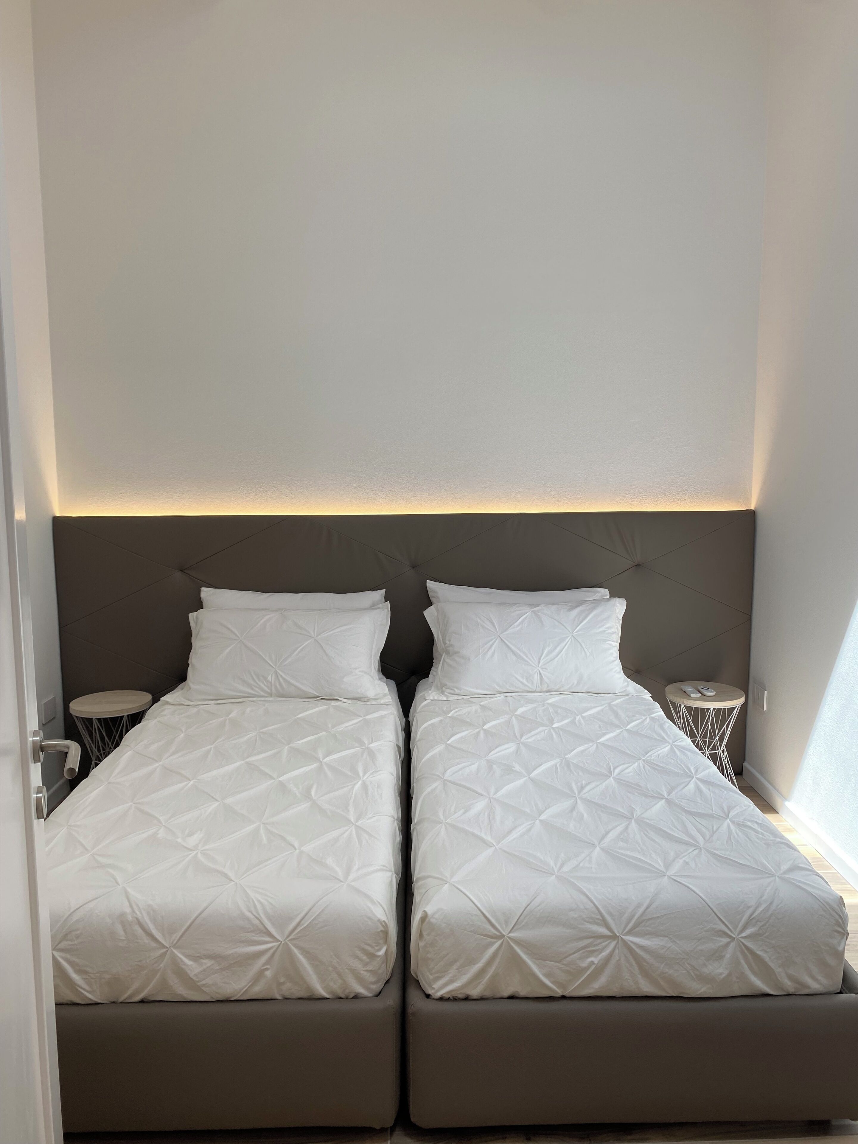 Un lit double avec une tête de lit, une table de chevet et une petite table ronde avec une lampe.