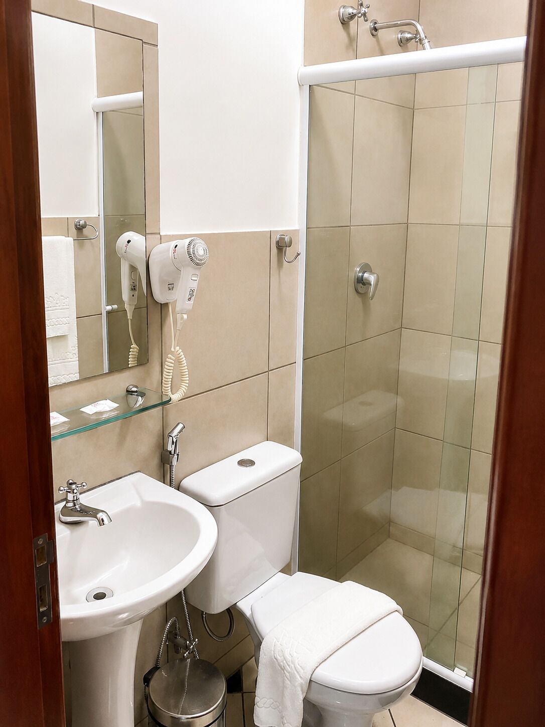A bathroom with a sink, toilet, and a glass-enclosed shower.