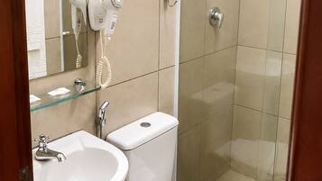 A bathroom with a sink, toilet, and a glass-enclosed shower.