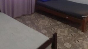A small room with a single bed, a wooden headboard, and a window with purple curtains. - Alugo Casa NA Praia Grande Próximo AO Centro DE Mongaguá Acomoda ATE 15 Pessoas (Cidade das Crianças Praia Grande)