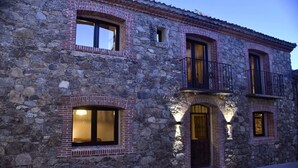 A stone building with multiple windows and a balcony. - La Casa del Guarda, an exclusive rural house 4* (Sotosalbos)