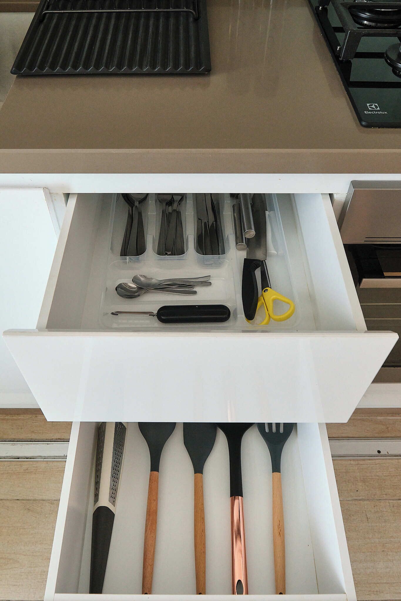 A drawer with kitchen utensils including knives, spoons, and spatulas.