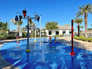 A water play area with various colorful structures and palm trees in the background.