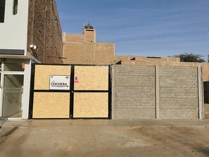 Commercial space with a boarded-up entrance, featuring a sign reading 'COCHERA'.