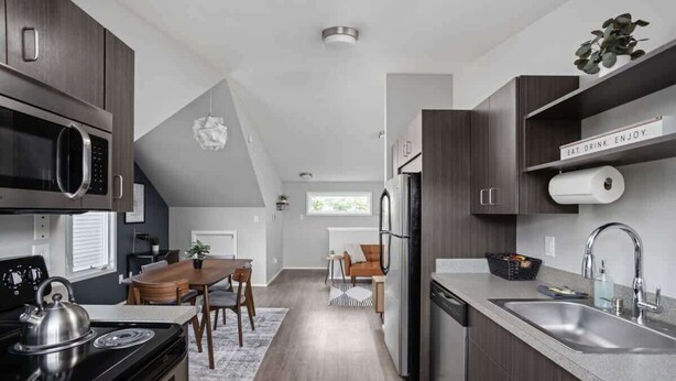 Una cocina moderna con armarios de madera oscura, electrodomésticos de acero inoxidable y una isla central.