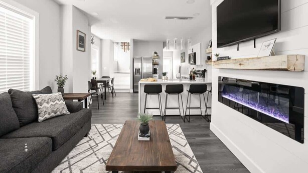A modern living room with a sofa, coffee table, and fireplace. - Heart of Indy | Sleeps 6 | Modern Home (Indianapolis)