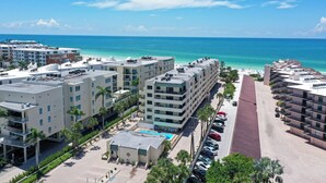 A hotel with multiple floors, a rooftop pool, and a view of the ocean. - Steps to Siesta Key Beach! We offer 3-night rentals! Beach gear included! (Sarasota)