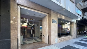 A hotel entrance with a glass door, a sign indicating it is the Hotel Paname, and a tiled floor with a checkered pattern. - Hotel Paname (Buenos Aires)