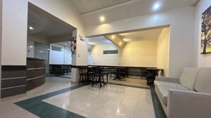 A spacious lobby with a white reception desk, multiple seating areas, and a modern ceiling design. - Hotel Paname (Buenos Aires)