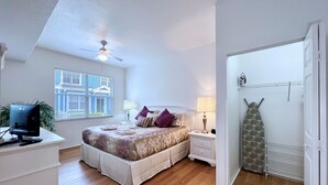 A bedroom with a bed, bedside tables, a desk with a computer, a ceiling fan, and a window with blinds. - EPIC VALUE-Disney Retreat! Magical Kid Friendly! (Kissimmee)