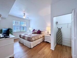 A bedroom with a bed, bedside tables, a desk with a computer, a ceiling fan, and a window with blinds. - EPIC VALUE-Disney Retreat! Magical Kid Friendly! (Kissimmee)
