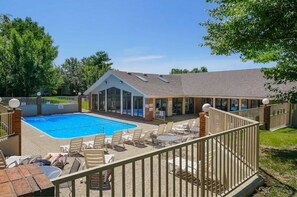 Relax by the rectangular pool surrounded by a deck and lounge chairs on the covered patio.