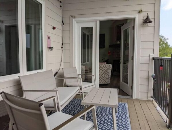 Relax in this serene outdoor space with a seating area and glass door leading to a cozy interior room.