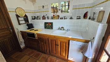 Een oven, een kookplaat, kookgerei, borden en bestek