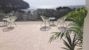 A terrace with outdoor seating and a view of the sea. - Sea apartment 1A with pool, 2 min. canyamel beach (Capdepera)