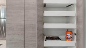 Uma cozinha com eletrodoméstico embutido, um armário branco com uma caixa Jenga e um livro.