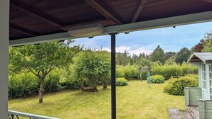 A covered outdoor area with a view of a well-maintained garden and a small building. - Holiday cottage tummel valley beautiful views. Own garden dog friendly  (Pershire)