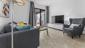 A modern living room with a sofa, armchair, coffee table, and a TV. - Hola Arnage (Puerto del Carmen)