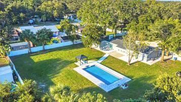 Zona residencial con piscina, terraza techada y patio cercado.