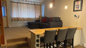 Un espacio habitable compacto con kitchenette, comedor y sofá.