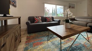 A living room with a sofa, a coffee table, and a TV.
