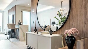 A modern living room with a large round mirror, a minimalist console table, and a vase with flowers. - Penthouse with sea views in San Pedro de Alcántara by Costarentals - Ref M34 (San Pedro Alcántara)