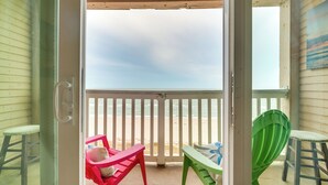 A beach view from a covered porch with a white railing, two chairs, and a bench. - Beachfront Corpus Christi Condo w/ Pool Access! (Corpus Christi)