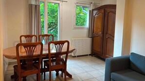 Un comedor con una mesa y sillas de madera, un radiador y un armario.