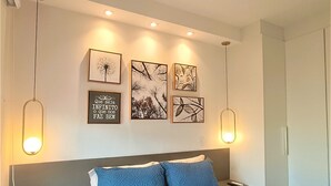 Ett hotellrum med en stor säng, två sängbord, ett litet bord och en vägglampa.