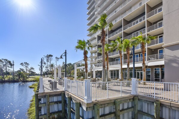 A multi-story hotel with balconies, a waterfront view, and outdoor seating areas. - BEAUTIFUL GULF VIEW CONDO w/5 POOLS, HOT TUB & EASY BEACH ACCESS w/2 BDR 2 BATH (Panama City Beach)