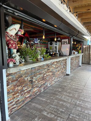 En bar med murstensvæg, en bardisk med planter og et skilt for Lagunitas IPA.