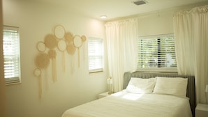 A bedroom with a large bed, a bedside table, and a wall-mounted dreamcatcher. - Top Location, 1 mile from Airport ,Full House, Big Patio, Free Parking. (Miami)