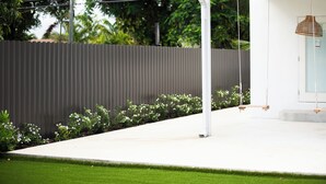 A modern outdoor patio area with a white pergola, a swing set, and a grey fence. - Top Location, 1 mile from Airport ,Full House, Big Patio, Free Parking. (Miami)