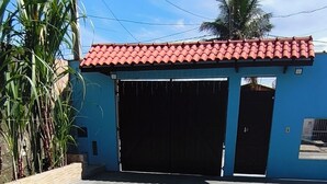Ein blaues Gebäude mit rotem Ziegeldach, zwei geöffneten Garagentoren und einem Betonboden.